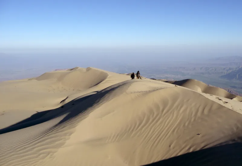 Cresta de la Duna Cerro Blanco con dos personas y el paisaje al fondo.