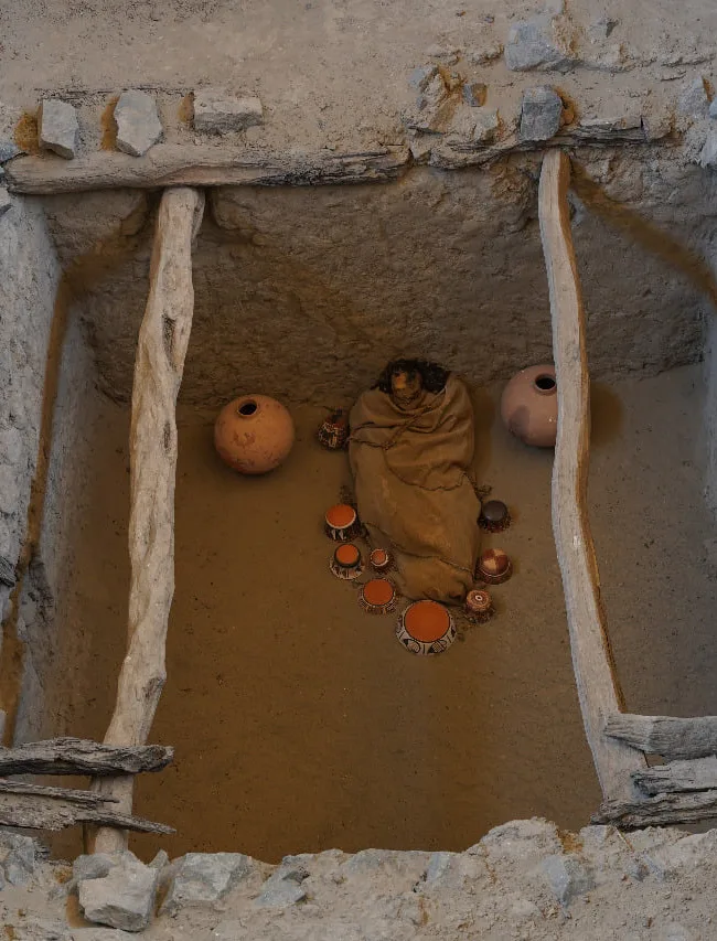 Recinto excavado con piezas de cerámica y elementos de un contexto funerario.