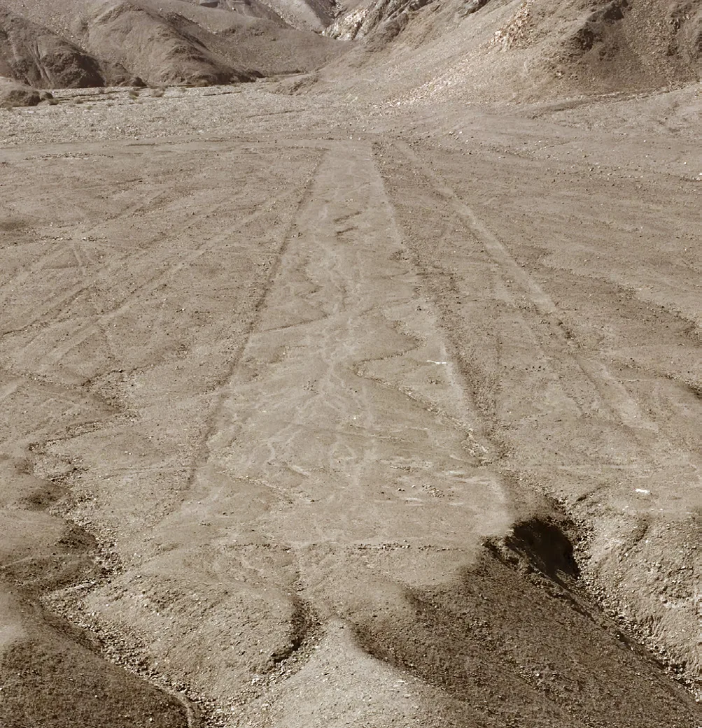 Líneas y figura trazadas sobre una ladera desértica.