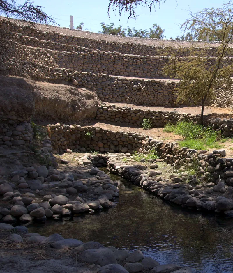 Canal con agua y muros de piedra escalonados en los Acueductos de Ocongalla.